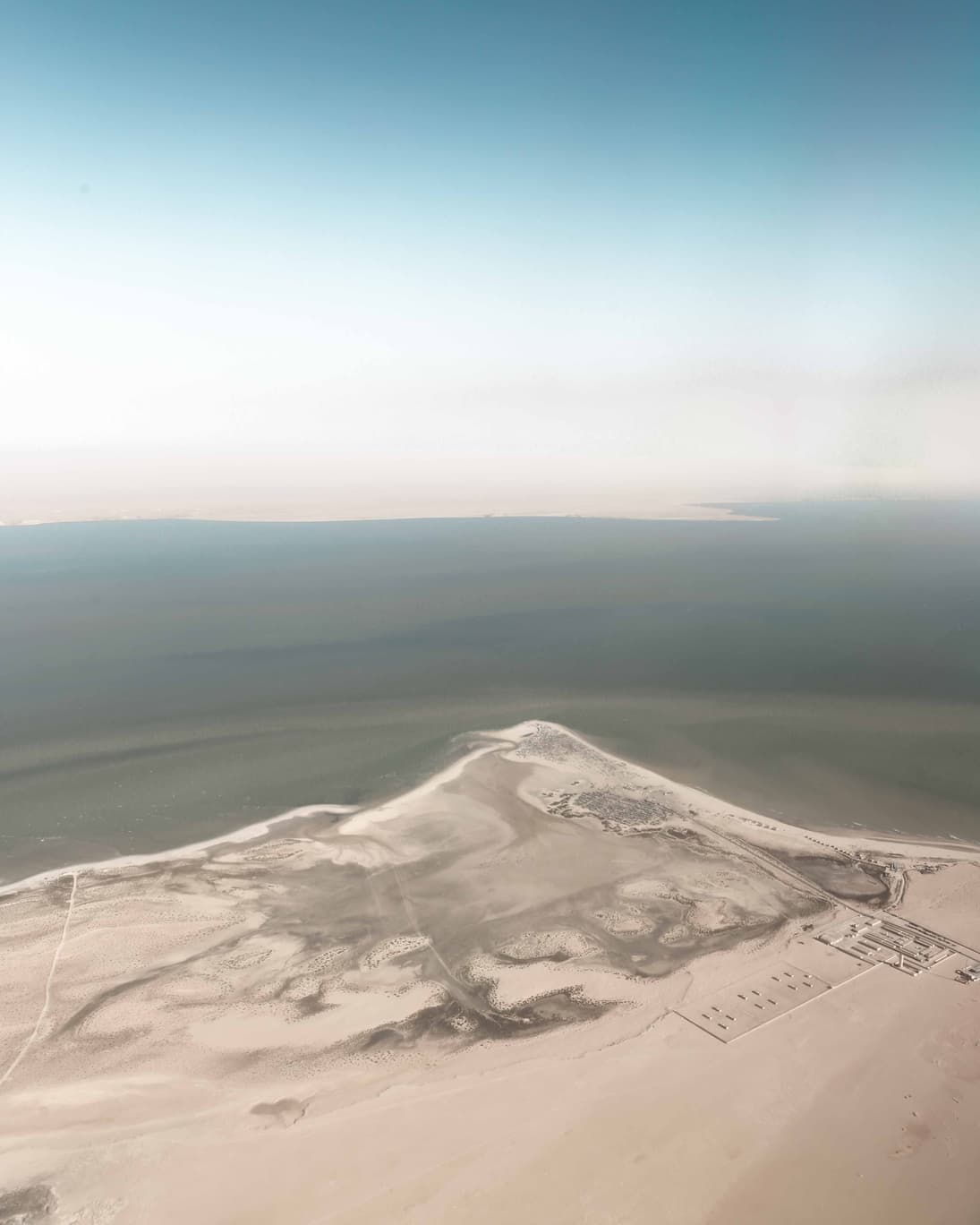 Figure walking toward horizon with footprints